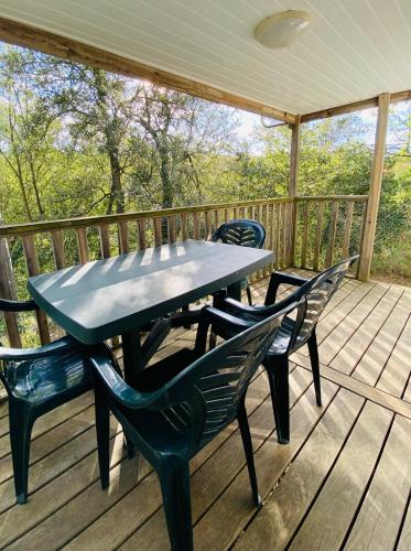 - une table de pique-nique et des chaises sur une terrasse dans l'établissement Camping Maureillas, à Maureillas