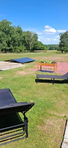 a picnic table and a bench in a field at Maison Mathieu in Bilzen