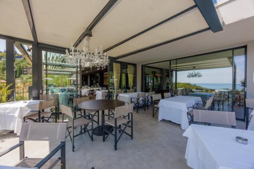 a dining room with tables and chairs and windows at Deville & Spa in Costermano sul Garda
