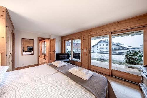 a bedroom with a large bed and a large window at Ride Inn Verbier - B&B - private room and ensuite bathroom in Verbier