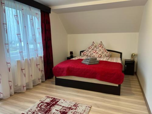 a bedroom with a red bed with a red blanket at Pensiunea Crinul Bucovinei 