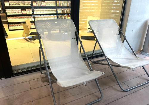 two white chairs sitting in front of a store at スゴイサウナ アンド ステイ 麻布十番駅前 男性専用 in Tokyo