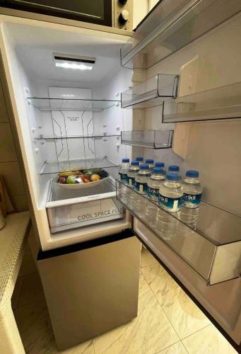 an empty refrigerator with bottles of water in it at LXRY Apt Bestekar Avenue at the heart of Ankara in Ankara