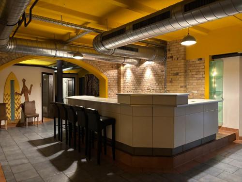 a restaurant with a bar with black chairs in a room at Monteurwohnung am Bahnhof in Zerbst