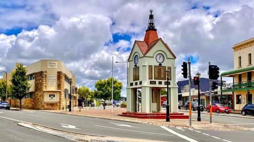 a building with a clock tower on the corner of a street at 2 Bedrooms Minimalist Home in Moss Vale in Moss Vale