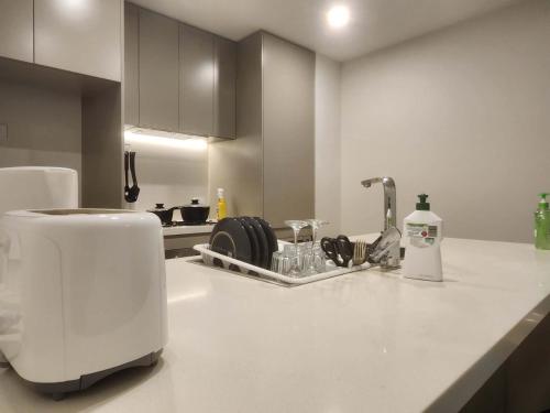 a kitchen counter with a toaster and a sink at Skyline Comfort - Sydney Olympic Park in Sydney