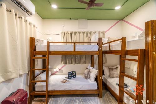 two bunk beds in a room with a ceiling at Zostel Chennai, Anna Nagar in Chennai