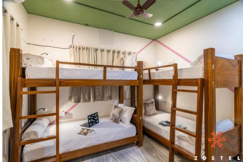 a room with three bunk beds and a ceiling at Zostel Chennai, Anna Nagar in Chennai