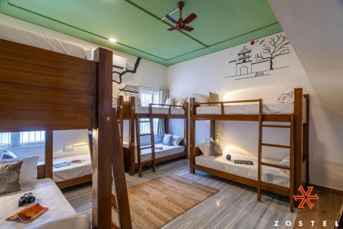 a room with three bunk beds and a ceiling at Zostel Chennai, Anna Nagar in Chennai