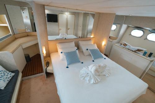 ein Zimmer mit einem großen weißen Bett und zwei Stühlen in der Unterkunft Bona Dea 27m Motoryacht in Bodrum City