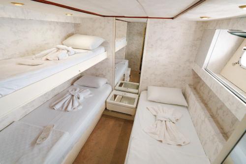 ein kleines Zimmer mit zwei Betten und einem Spiegel in der Unterkunft Bona Dea 27m Motoryacht in Bodrum City