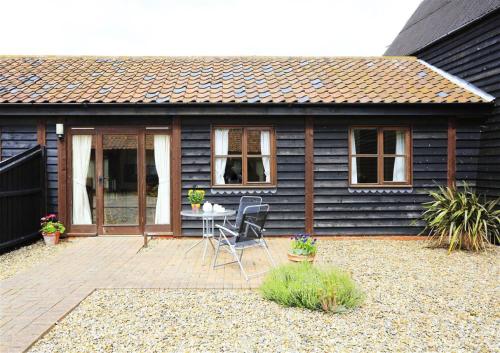 a house with a patio with a table and chairs at The Tack Room in Wangford