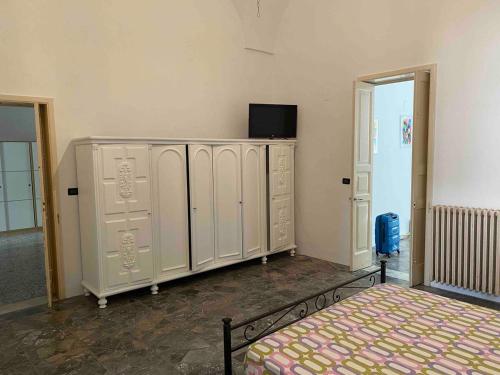 a room with white lockers and a bed at Casa Sole - Cursi in Cursi