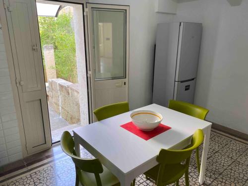a kitchen with a white table and green chairs at Casa Sole - Cursi in Cursi