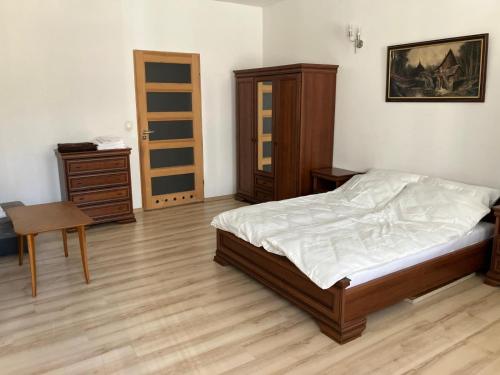a bedroom with a bed and a table and a desk at Apartament Głęboka 19 in Cieszyn