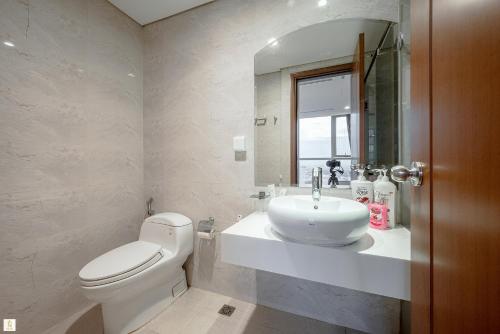a bathroom with a white toilet and a sink at The Peak Suite at Landmark Plus in Ho Chi Minh City