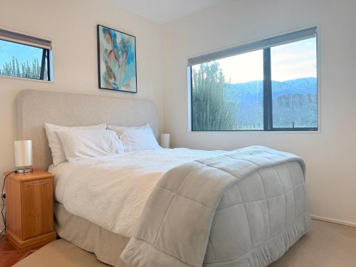 a bedroom with a bed and a large window at Lakeside Retreat in Cromwell