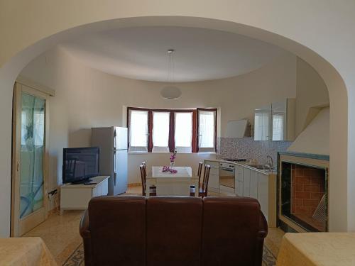 un soggiorno con un divano, un tavolo e una cucina di Dimora del Sole Salento a Taurisano