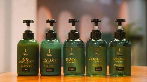a group of four green bottles sitting on a table at ELIVAAS Kamerios Maris 1BHK Apartment with Jacuzzi in Goa