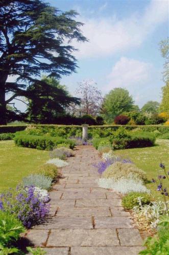 a stone path in a garden with purple flowers at Garden View in Parham