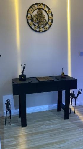 a black piano with a clock on the wall at Luxury 3 Bedroom Terrace House in Lekki Phase 1 24hr light & Security in Lekki