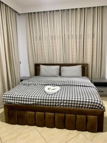 a bed with a black and white checkered mattress with a white shoe on at Luxury 3 Bedroom Terrace House in Lekki Phase 1 24hr light & Security in Lekki