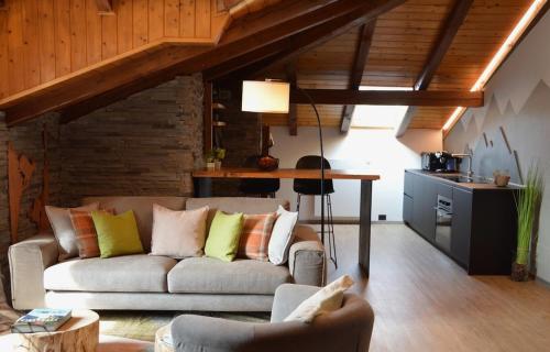 a living room with a couch and a table at Mountain Suite with tub and view, Alpine design in Sanzeno