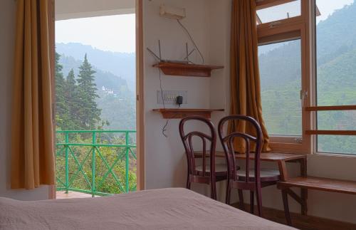 a bedroom with a bed and a desk and a window at Jaadooghar Rainbow Farms in Mussoorie