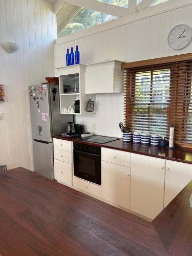 a kitchen with white cabinets and a stainless steel refrigerator at Shick-Shack in Eersterivierstrand
