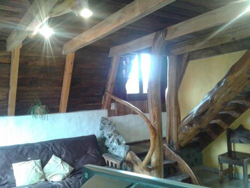 a living room with a couch and wooden ceilings at Del Viejo Camino in El Bolsón