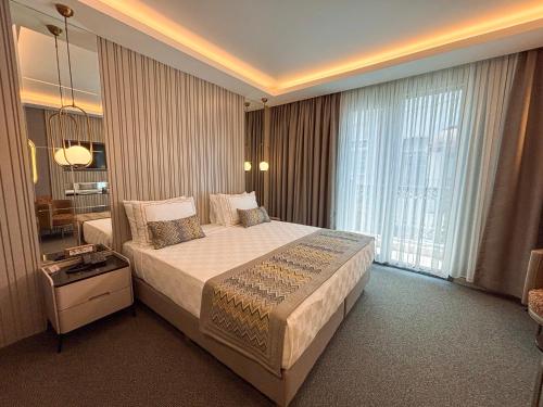 a bedroom with a large bed and a large window at Saygın Hotel Beşiktaş in Istanbul