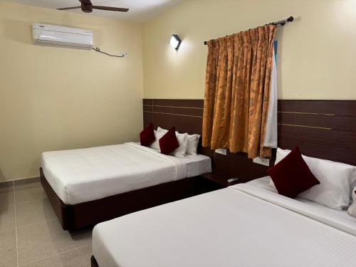two beds in a hotel room with two beds at Hotel Annamalai International in Puducherry