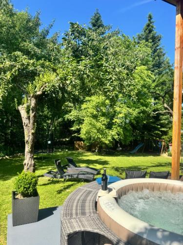 a hot tub in a yard with a tree at Chatka in Roztiezi in Roztěž
