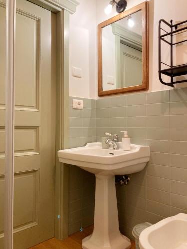 a bathroom with a sink and a mirror and a toilet at Oltrebosco Casa Vacanze in Valfabbrica