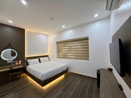 a hotel room with a bed and a television at Homestay Coffee 135 in Kỳ Vĩ