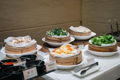 uma mesa coberta com tigelas de diferentes tipos de comida em KKS Hotel em Hualien