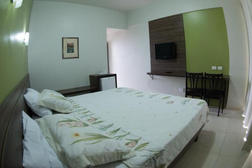 a bedroom with a large bed and a television at Panorama Hotel in Juazeiro do Norte