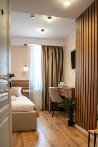 a hotel room with a bed and a desk at Volotel SkyWay in Cluj-Napoca