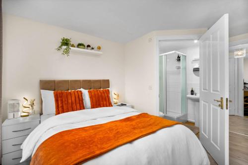 a white bedroom with an orange blanket on a bed at Dote Haven Stylish 2 Bed Apartment - Free Parking and Free High Speed WIFI in Birmingham
