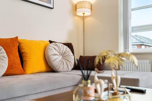 a living room with a couch with pillows and a table at Dote Haven Stylish 2 Bed Apartment - Free Parking and Free High Speed WIFI in Birmingham