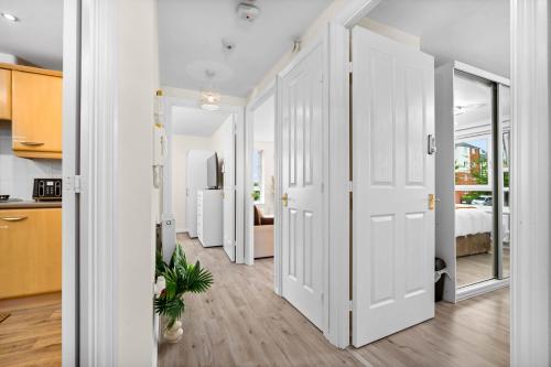 a hallway with white doors and a bedroom at Dote Haven Stylish 2 Bed Apartment - Free Parking and Free High Speed WIFI in Birmingham