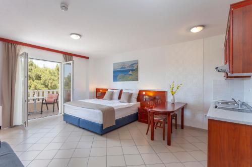 a bedroom with a bed and a kitchen with a sink at Apartments Vila Kristina in Baška Voda