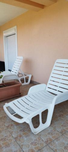 two white beds sitting next to a wall at Apartmani Relax D in Tivat