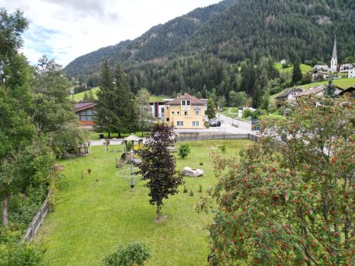 a green field with a house in the middle of a mountain at Appartmenthotel Residence Elvis in Ortisei