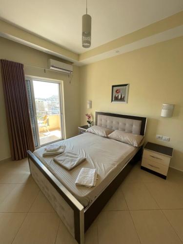 a large bed in a bedroom with a window at Honey Residence in Sarandë