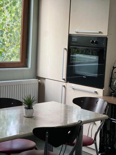 a kitchen with a table with chairs and a microwave at Georges Apartment in Tbilisi City