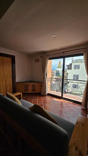 a living room with a couch and a large window at Yangla Home in Kathmandu