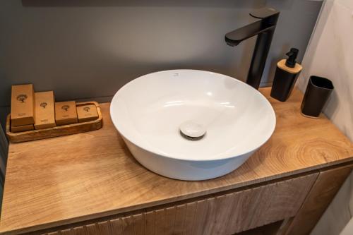 a white sink on a wooden counter in a bathroom at Volotel SkyWay in Cluj-Napoca