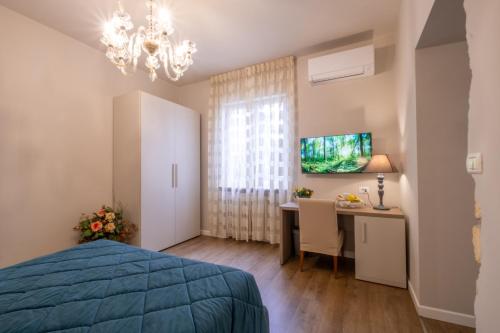 a bedroom with a bed and a desk and a tv at B&B Accademia in Verona