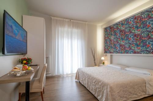 a bedroom with a bed and a table and a painting at B&B Accademia in Verona